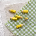 Close-up of cute yellow pencil alloy beads with metal pins for DIY jewelry making - Yellow