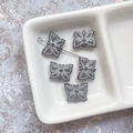 Gros plan de perles papillon en verre gris avec bords dorés pour la création de bijoux - Gris avec Tracé Blanc