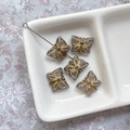 Vue détaillée de perles en verre tchèque violettes avec motifs floraux dorés pour bijoux - Gris Transparent avec Tracé à l'Or