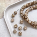 Macro shot of vintage Czech style textured glass beads in cream with brown details - Rounded Cube (4#) / Beige Coffee