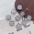 Macro view of square grey Czech glass flower beads with etched Picasso finish detail - 13#