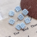 Macro detail of light blue glass flower beads with metallic luster for DIY jewelry making - Size 7