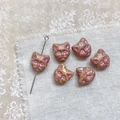 Macro detail of cat-head shaped Czech glass beads with vintage glaze and vertical holes - Yellow Pink