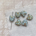 Macro shot of sky blue cat-shaped beads with vintage textured glaze for DIY jewelry - Yellow Coffee Blue