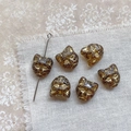 Macro detail of amber cat-head glass beads with gold accents for DIY jewelry making - Transparent Coffee Gold