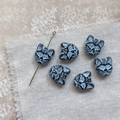 Macro view of vintage cat-shaped glass beads for DIY jewelry making on linen background - Black Blue