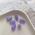 Close-up of translucent purple teardrop glass beads with vertical striped texture for DIY crafts - 6# Transparent Purple Purple Edging