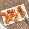 Macro detail of marbled orange glass flower beads for DIY jewelry making and crafts - Orange