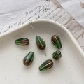 Macro detail of teardrop Czech glass beads with vintage gold stripes for jewelry making - 1# Green Coffee Gradient Gold Edging