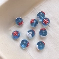 Gros plan de perles en verre bleu avec motif d'étoile de mer rouge pour bijoux DIY - Design d'Étoile de Mer et Méduse