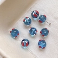 Détail macro de perles en verre bleu avec motifs marins faits main pour bijoux DIY - Style Poisson Rouge