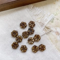 Détail macro de perles fleurs en verre tchèque marron avec finition Picasso pour bijoux DIY - Ambre Café