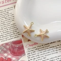 Détail de breloques étoiles de mer roses et dorées sur plateau pour bijoux DIY - Style Étoile de Mer (13#)
