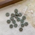 Macro detail of vintage green Czech glass flower beads with Picasso finish for DIY crafts - Green With Bright Brown