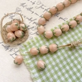 Macro detail of peach-shaped glazed beads for DIY jewelry making in a mini bamboo basket - Light Apricot