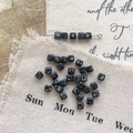 Macro detail of vintage black cube glass beads with Picasso finish on rustic linen cloth - 2#
