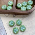 Macro detail of light green Czech glass beads with white floral patterns and star edges - Grass Green (9#)