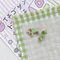 Close-up of handmade dachshund puppy pendants with green polka dot clothing and gold loops - Green