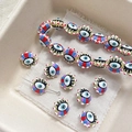 Macro shot of striped evil eye glass beads on linen for DIY jewelry making - Yellow-Green