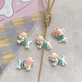 Detail shot of cute resin dog charms with hat and scarf for DIY jewelry making - Yellow and Blue Hat Puppy