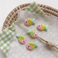 Close-up of five colorful hand-painted fish resin beads on a white linen cloth background - 12# Striped - Pink Head Light Green Tail