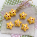 Macro shot of yellow star-shaped acrylic beads with fun expressions for DIY phone chains - Yellow-Star