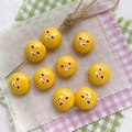 Macro shot of yellow round resin beads featuring red abstract expression for DIY jewelry - Yellow-Round