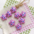 Macro view of purple star-shaped craft beads with cute faces for DIY phone charms - Purple-Star