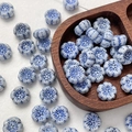 Macro view of blue and white floral glass beads with hand-painted glaze texture - 1 Piece / Blue White