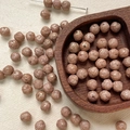 Close-up of 8mm dusty rose Czech glass beads with intricate engraved floral patterns - Dusty Rose Carved (2#)