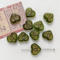 Macro shot of green heart-shaped glass beads with gold floral pattern and threading pin - 8# Olive Green