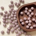 Macro shot of 8mm mauve Czech glass beads with detailed rose carving for DIY jewelry - Lotus Purple Carved (7#)