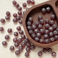 Macro detail of 8mm dark red Czech glass beads with vintage silver floral patterns - Dark Red Silver Pattern (8#)