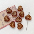 Macro shot of amber heart beads with gold floral engraving and bead threading detail - 14# Amber Brown