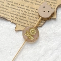 Detailed close-up of a pink translucent bead with gold sunflower engraving on a wood pin - Pink Gold Sunflower With Wood Cat Head (Style 3)