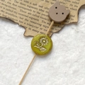 Detail of a yellow round bead with gold floral relief and a wooden bear charm ornament - Yellow Gold Sunflower With Wood Bear Head (Style 8)