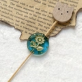 Macro shot of vintage blue Czech glass bead with gold floral engraving for DIY jewelry - Lake Blue Gold Sunflower With Wood Cat Head (Style 11)