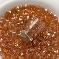 Makroaufnahme von orangefarbenen Glasperlen und Mini-Glasflasche für DIY-Schmuck - Orange
