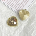 Macro shot of heart-shaped DIY charms with gold foil, dried flowers, and textured metal back - Gold Foil Red Flower Style