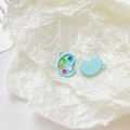 Macro shot of light blue palette alloy charms with colorful paint drops for DIY jewelry - Mint Blue Palette