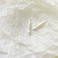 Detailed close-up of white paint brush alloy pendants with pink floral motifs for DIY jewelry - White Brush