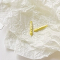 Detail of two yellow enamel paintbrush charms for DIY jewelry making on white paper - Yellow Paintbrush
