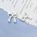Detailed view of white candy-colored bow charms for DIY jewelry and crafts making - White