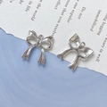 Macro view of silver bow-knot metal pendants for DIY jewelry and necklaces - Silver