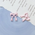 Macro view of pink bow-knot pendants with glossy enamel finish and secure metal hanging loops - Light Pink