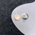 Macro-opname van zilveren gehamerde bedels en roze edelsteenhanger op een wit dienblad - Zilver Roze Ronde Hanger (23#)