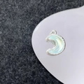 Detailopname van een zilveren maan hanger met lichtblauwe opaalsteen en gekartelde rand - Zilver Lichtblauwe Maan (38#)