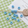Gros plan de perles d'espacement bleues en forme de fleur pour bijoux DIY et colliers - Bleu