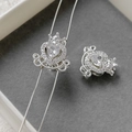 Macro shot of a silver heart-shaped pumpkin carriage charm with zircons on a jewelry tray - Silver White Zircon Carriage