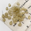 Detailed macro of leaf-shaped glass beads with golden veins for DIY jewelry making - 5-Pack / Clear